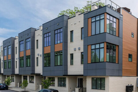 Front view of modern Bauhaus-style townhomes featuring large windows, mixed materials, and rooftop terraces – Buchanan Construction Commercial Asheville NC
